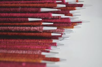 Close-up of multi colored pencils on table against white background