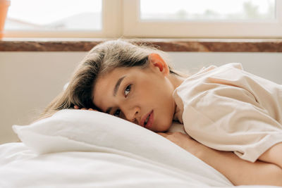 Portrait of a sensual beautiful young woman lying on the bed.