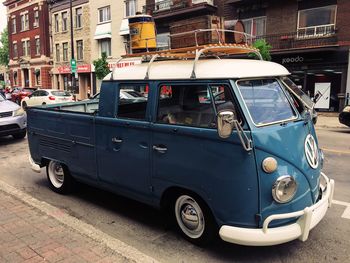 Vintage car on street against buildings in city