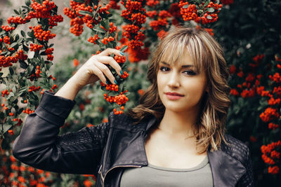 Portrait of young woman with fruits hanging on branch