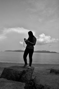 Full length of man standing on beach against sky