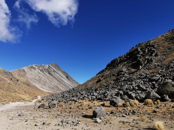 Scenic view of rocky mountains against blue sky