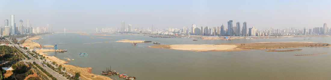 Panoramic view of river by city against sky
