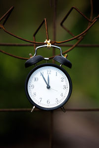 Close-up of clock hanging on rusty metal