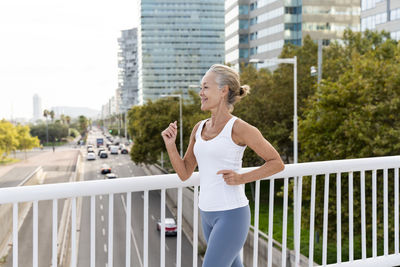 Woman jogging near railing in city