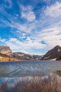 Scenic view of lake by mountains against sky