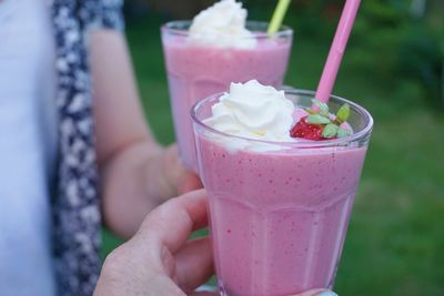 Cropped hands of people holding drinks outdoors