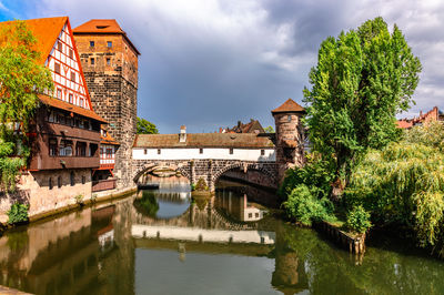 Arch bridge over river against sky