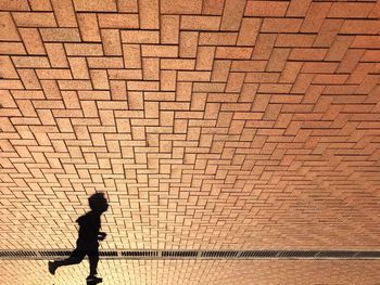 Child running against brick wall