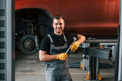 Man in uniform is in the auto service.