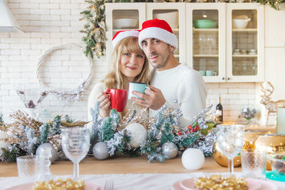Portrait of young couple drinking coffee at home