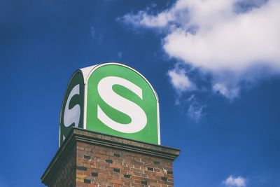 Low angle view of sign against blue sky