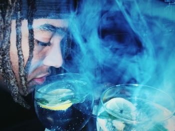 Close-up of man surrounded by smoke having alcohol