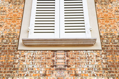 Low angle view of window on brick wall