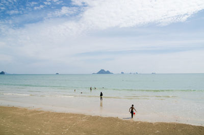 People standing on beach against sky