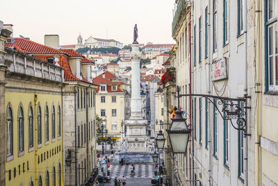 People on street amidst buildings in city