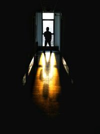 Silhouette man in dark room