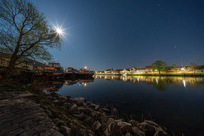 Scenic view of lake against sky at night