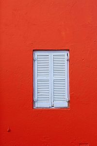 Close-up of window on red wall