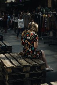 Woman wearing floral patterned dress while sitting at market