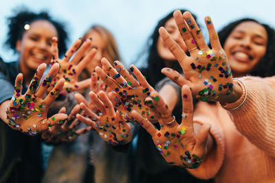 Female friends showing confetti on hands