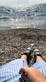 Low section of woman relaxing on beach