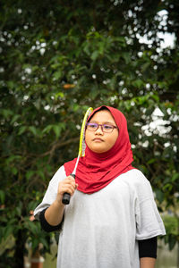 Young hijab asian girl with badminton racket at the park.