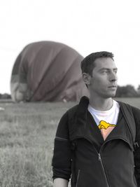 Portrait of young man looking away against sky