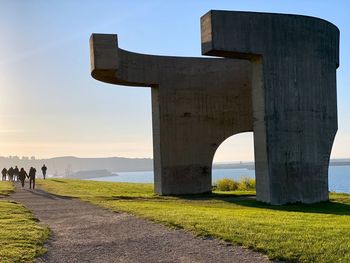 People on a path by a hill  against sky