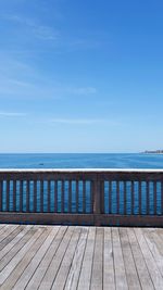 Pier over sea against blue sky