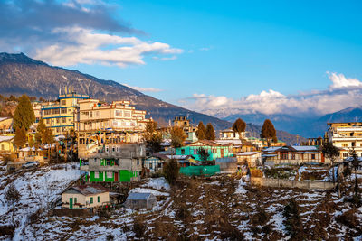 Buildings in city against sky during winter