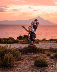 Couple kissing at sunrise with mount athos in the background