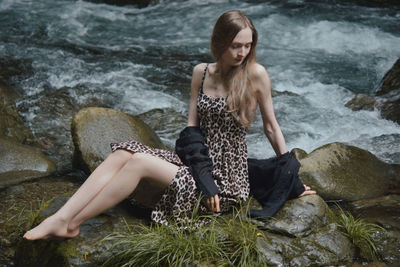 High angle view of woman sitting on rock