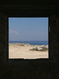 Scenic view of sea against sky seen through window