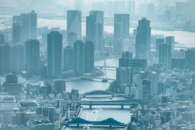 Aerial view of buildings in city against sky