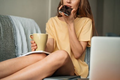 Midsection of woman holding coffee cup