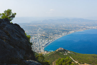 Aerial view of city by sea against sky