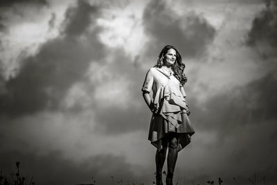 Low angle view of woman standing against sky