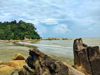 Scenic view of sea against sky with rocks and mountain.