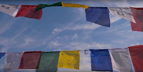 Low angle view of flags hanging against sky