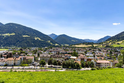 Townscape by mountains against sky