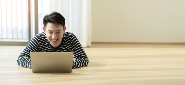 Man looking away while sitting on table