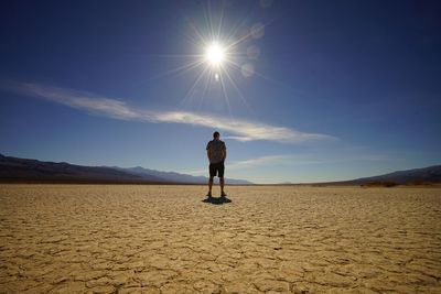 Man standing in the dry desert under the midday sun