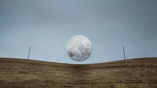 Full moon on electric wires. dark scary park  field, power  gray clouds. landscape misty panorama. 