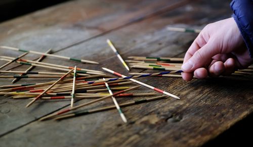 Close-up of hand holding multi colored wooden table