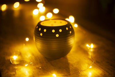 Close-up of illuminated string lights with decoration on table