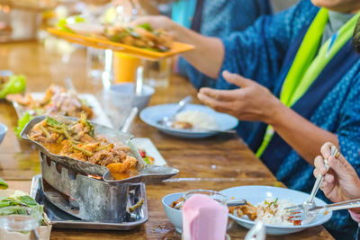 Midsection of woman having food in restaurant