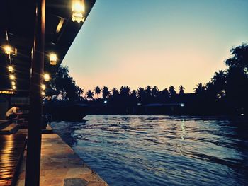 Swimming pool by sea against sky at night