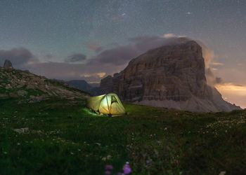 Tent on field by mountain against sky