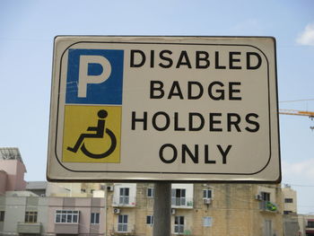 Low angle view of road sign against sky
